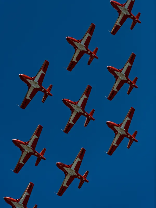 Tight close-up of red and white Snowbirds jets flying in diagonal formation