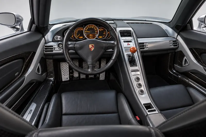 Driver-side interior view of a Carrera GT cockpit with leather seats and centre console